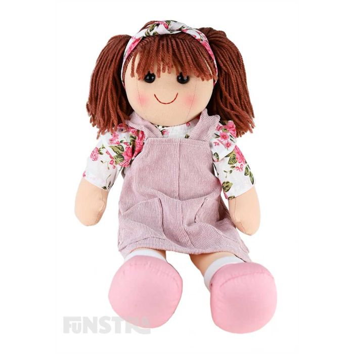 Alice is a gorgeous doll with a soft cloth body and reddish-brown hair tied back in pigtails with a headband and wears a corduroy pink pinafore dress over a floral white and pink blouse.