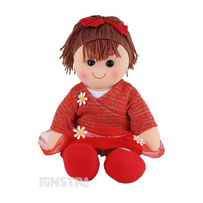 Bella is a beautiful doll with a soft cloth body and brown hair tied in a ponytail with a red bow and wears a red tulle skirt and crossover top embellished with appliqué daisies.