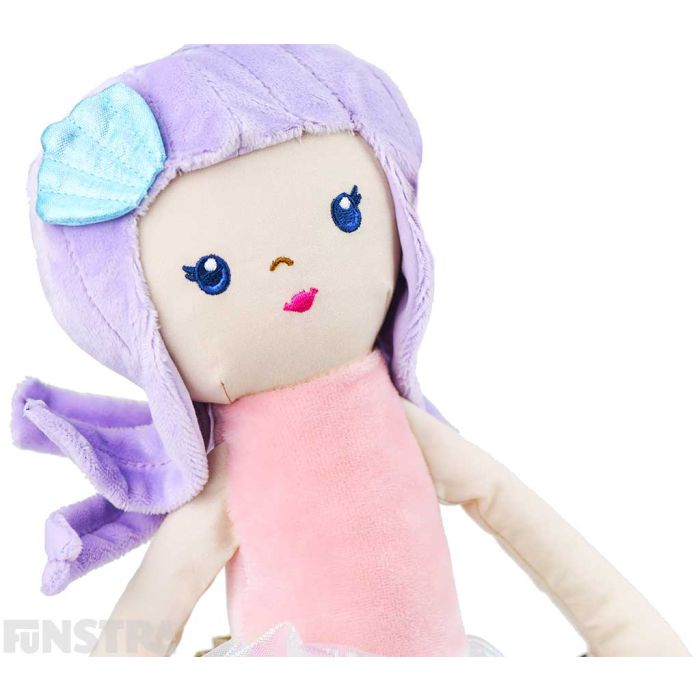 A sparkly seashell hair accessory in her purple hair and beautifully embroidered facial features, the plush mermaid is stunning.
