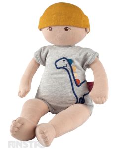 Adorable organic baby doll, Kye, wears a fun dinosaur jumpsuit and bonnet with a soft cloth fabric body and weighted bottom.