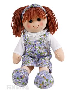 Emily is a sweet doll with a soft cloth body 
 with auburn hair tied in pigtails, wearing a headband and a lavender floral springtime print pinafore dress.
